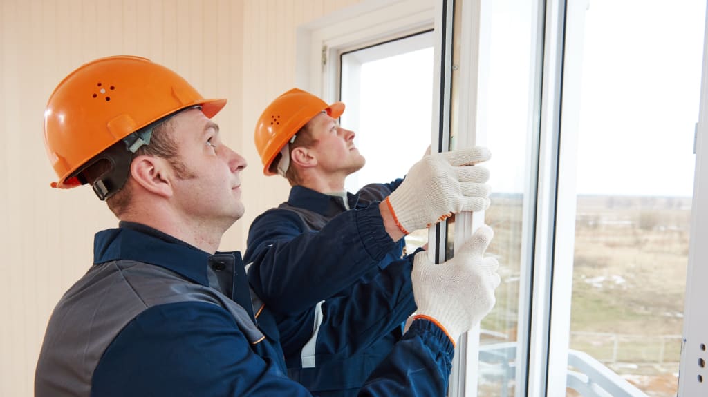 Two contractors changing windows